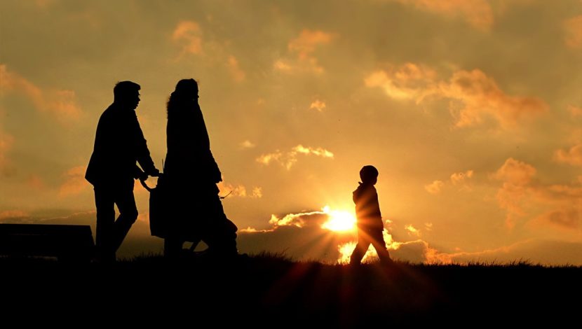 refugees walking in sunset
