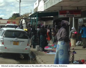 informal vendors selling their goods on a sidewalk in Zimbabwe