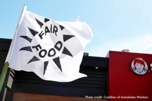 White flag with "Fair Food" logo flying in front of a Wendy's fast food restaurant