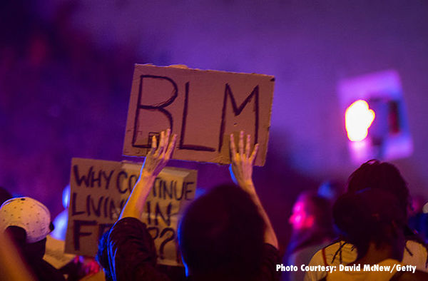A Black Lives Matter sign being held at a rally