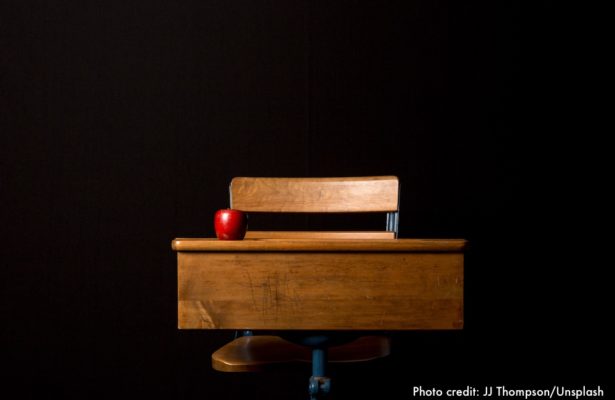 Desk and chair with red apple on the desk.