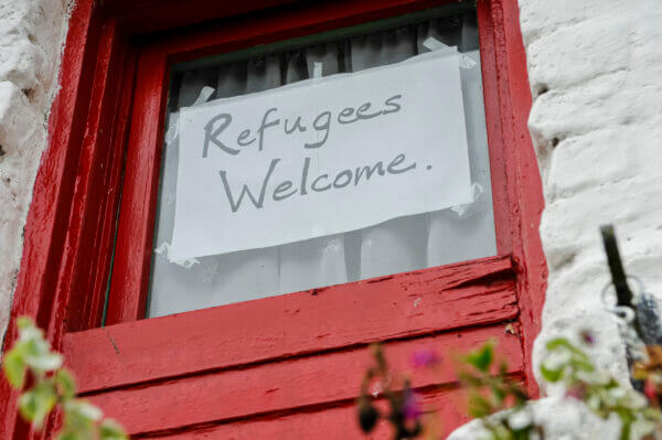 A sign reading "Refugees Welcome"