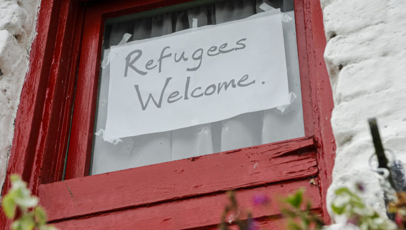 A sign reading "Refugees Welcome"