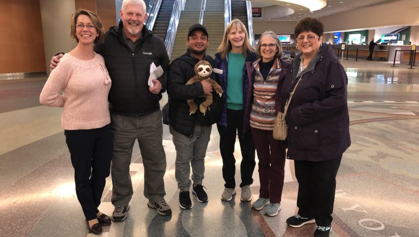 A group of UUs greet Roberto at the airport.