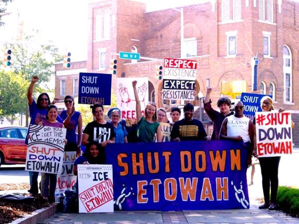 Members of the organization holding a banner and posters