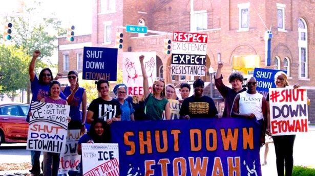 Members of the organization holding a banner and posters