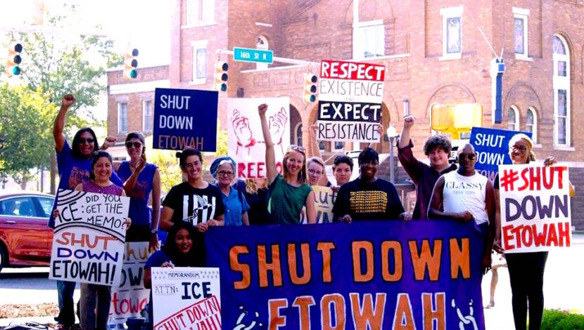 Members of the organization holding a banner and posters