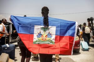 A Haitian man holding a flag.