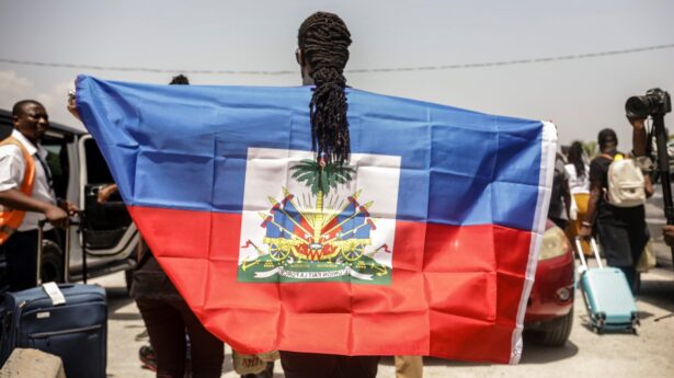 A Haitian man holding a flag.