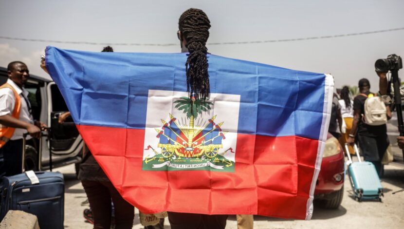 A Haitian man holding a flag.