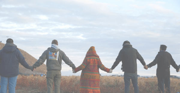 A group of Indigenous people holding hands