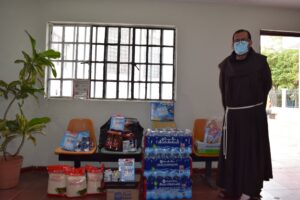 An Albergue staff member standing next to food supplies