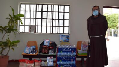 An Albergue staff member standing next to food supplies