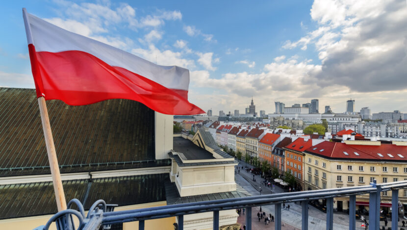 Poland Flag in Blue Sky and Warsaw in background