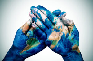 A pair of hands with the globe painted over them
