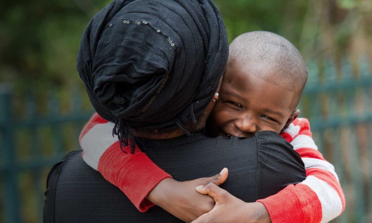 Haitian mother and son holding each other