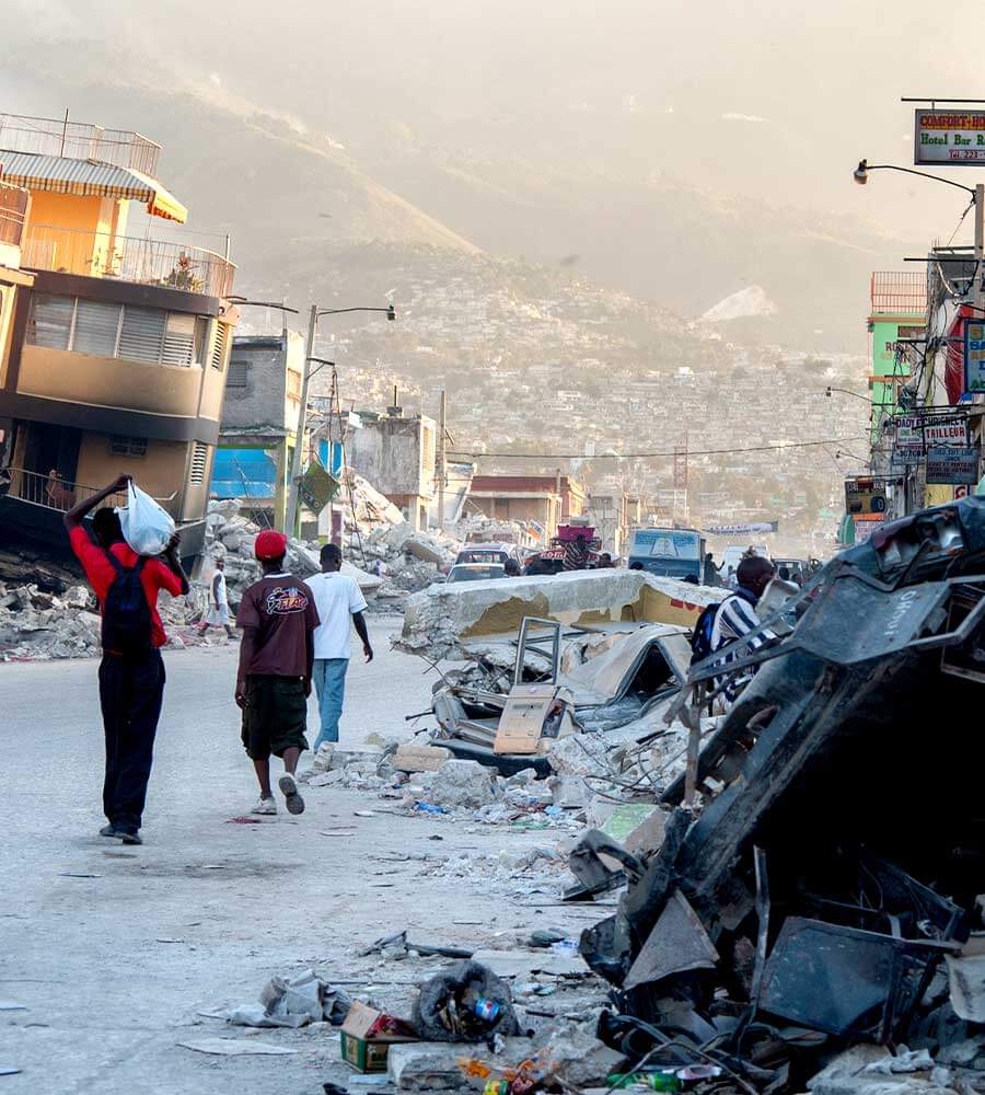 People walk past devastation in red-zoned area of Port-au-Prince, Haiti after an earthquake