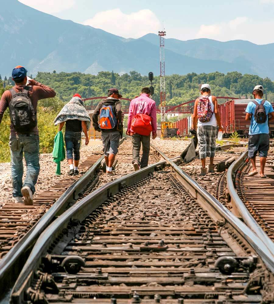 A group of migrants of Central American origin waits on the railway line to get on a container train